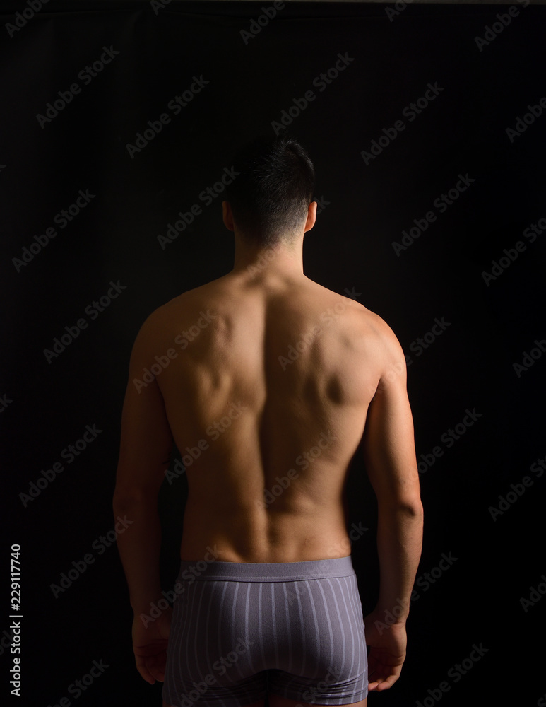 Fototapeta premium a man from behind in black background