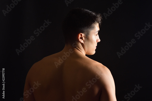 a man from behind in black background