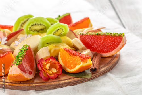Fresh fruits in plate on wooden table