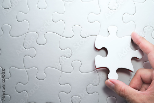 Fotografie Putting last jigsaw puzzle piece