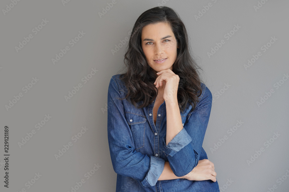 Brunette woman standing on grey background, isolated Brunette woman standing on grey background, isolated