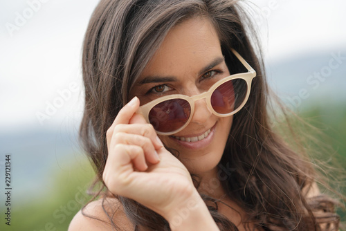 Photos Portrait of smiling brunette woman wearing sunglasses