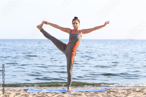 Woman practicing yoga on se...
