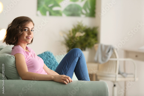 Beautiful young woman resting on sofa at home