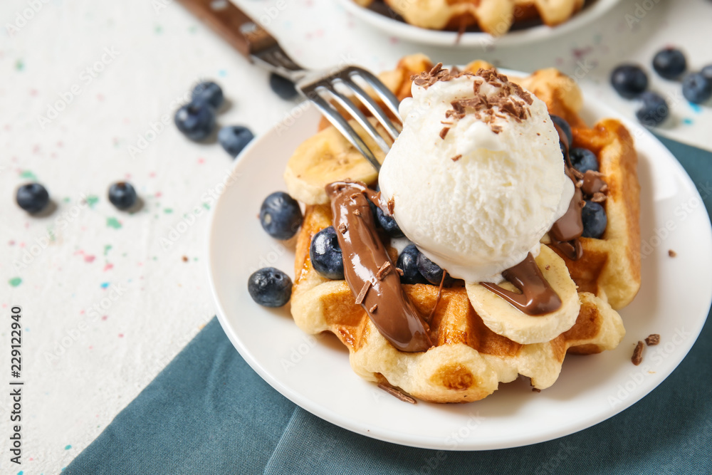 Delicious waffles with banana slices, blueberries and ice cream on plate Delicious waffles with banana slices, blueberries and ice cream on plate