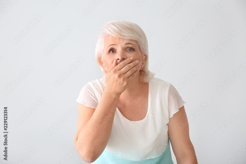 Portrait of shocked mature woman on light background Portrait of shocked mature woman on light background