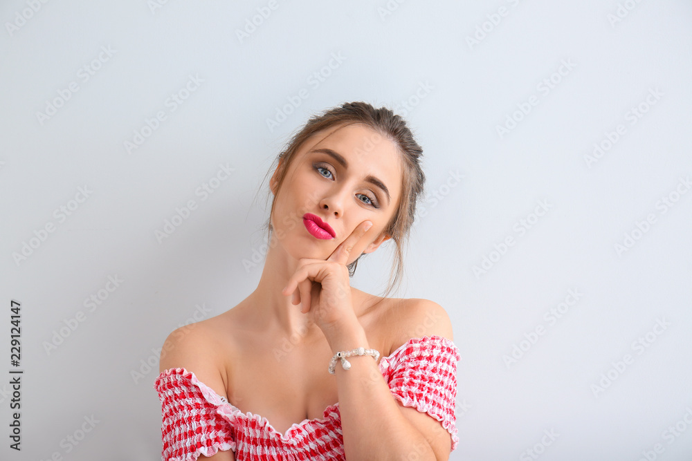 Thoughtful young woman on light background Thoughtful young woman on light background