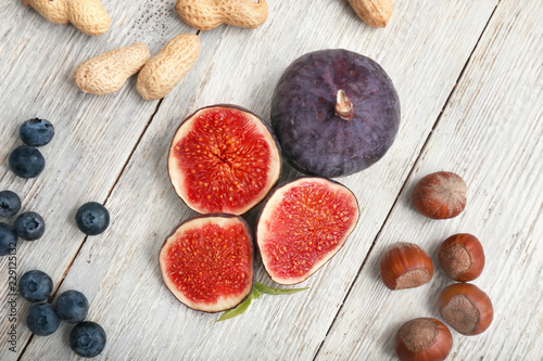 Fototapeta Naklejka Na Ścianę i Meble -  Fresh ripe figs with nuts and blueberries on wooden table