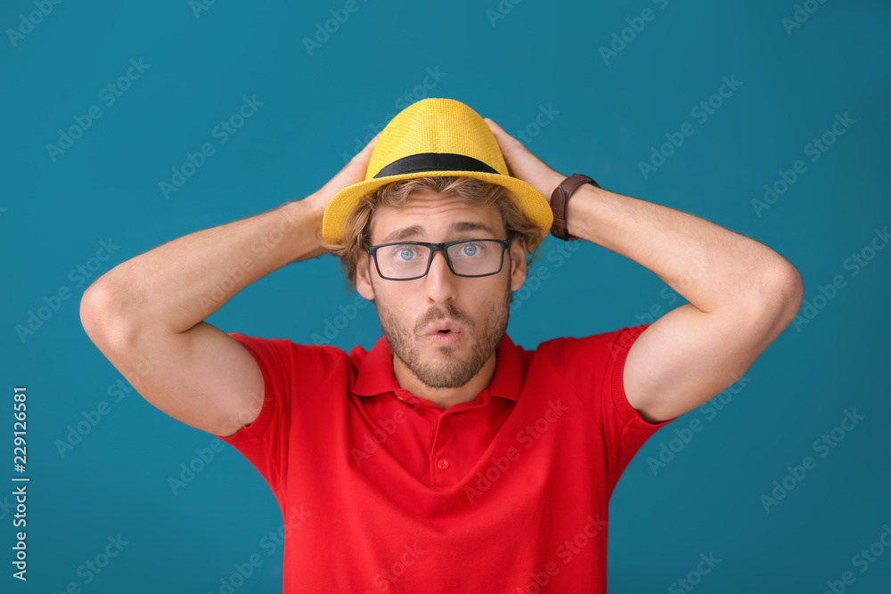 Handsome shocked man on color background