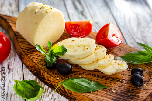 Mozzarella cheese with tomatoes and Basil on wooden background