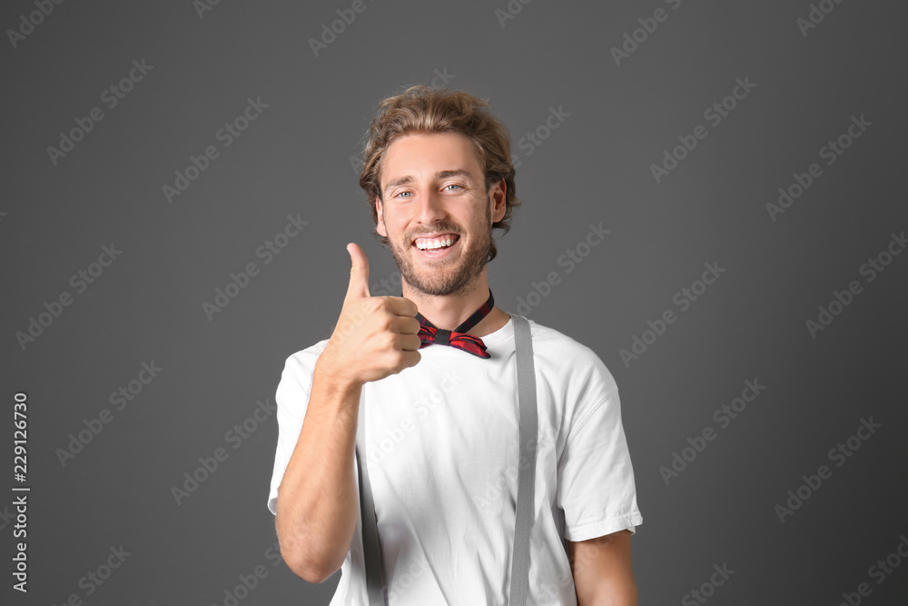Portrait of handsome man showing thumb-up on grey background Portrait of handsome man showing thumb-up on grey background