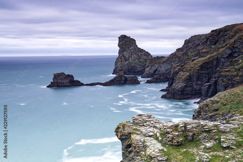 Beautiful west Cornwall coastal landscape at Bossiney, at the head of Rocky Valley, near Tintagel. Taken with long shutter speed blurring water movement and clouds