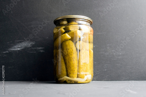 Jar of pickled cucumbers close-up on gray background