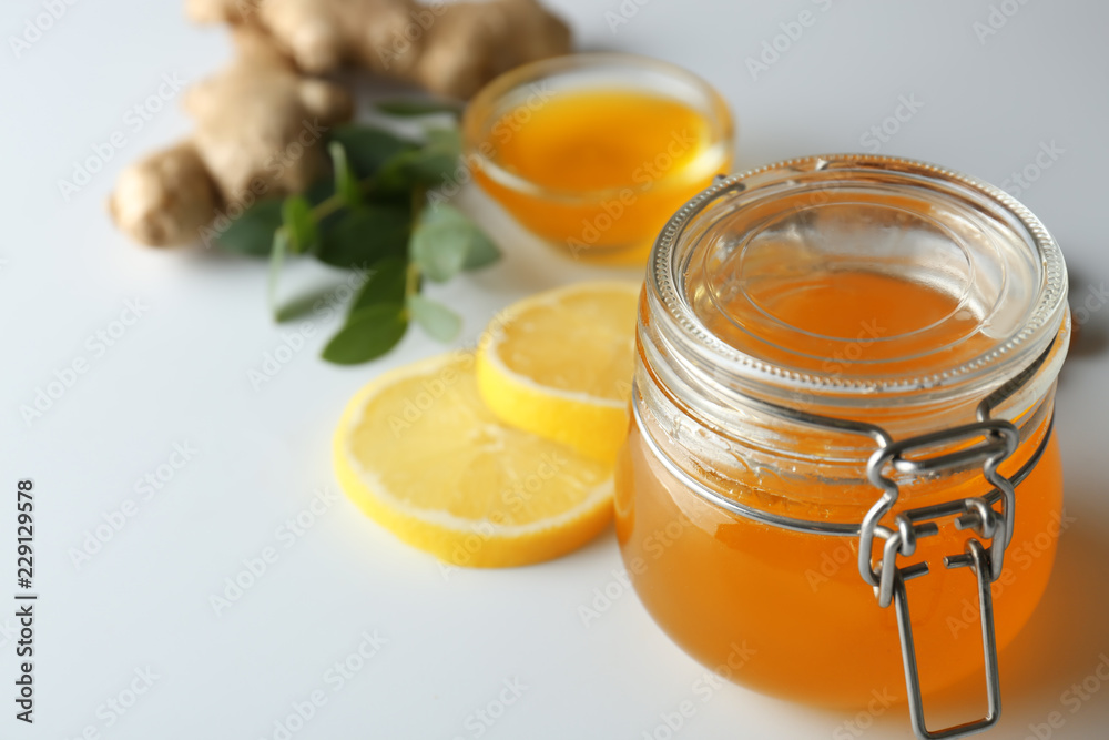 Jar with honey on light background, closeup Jar with honey on light background, closeup