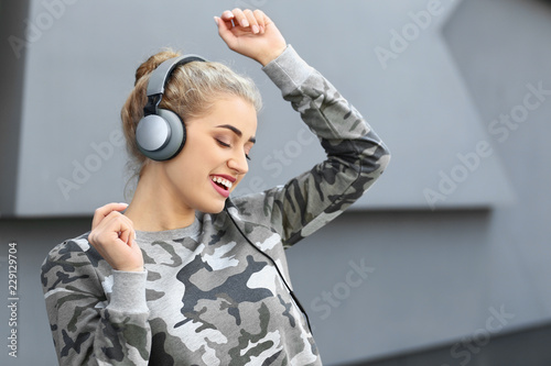 Beautiful young woman listening to music outdoors photo