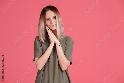 Portrait of young attractive woman in green T-shirt is touched.