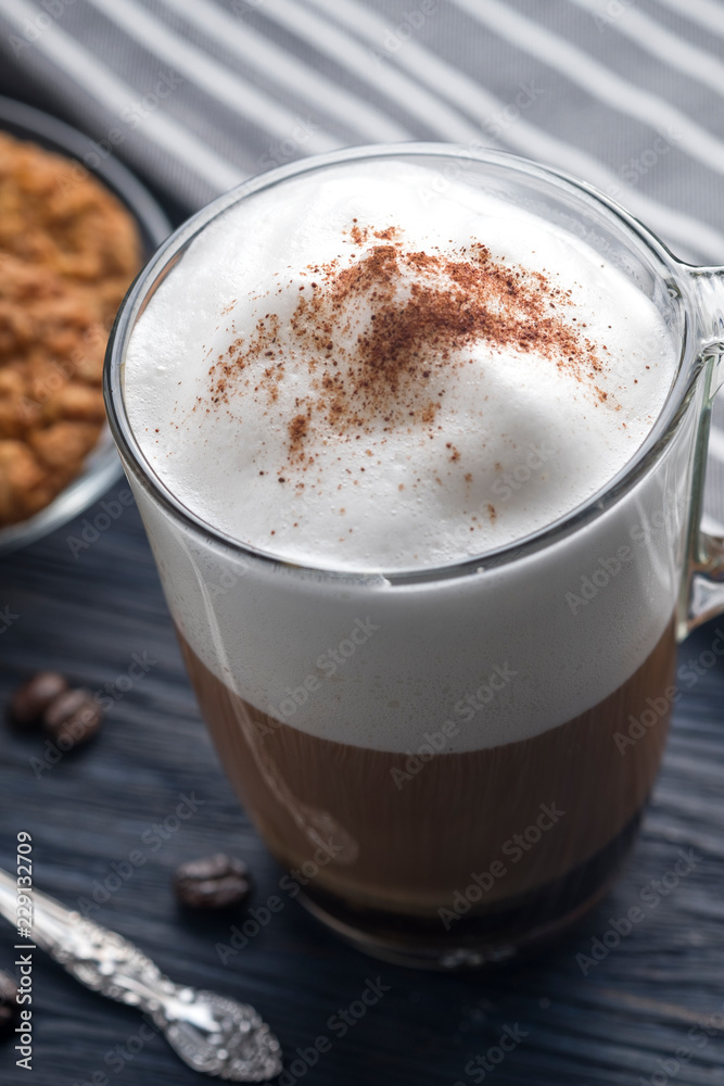 Glass cup of latte coffee on wooden table Glass cup of latte coffee on wooden table