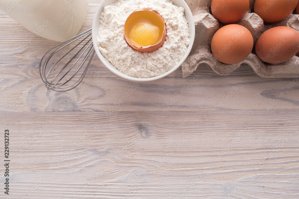 Flat lay of Ingredients for baking. Flour, eggs, milk, yolk on a table. Sweet pastry baking concept. Top view Flat lay of Ingredients for baking. Flour, eggs, milk, yolk on a table. Sweet pastry baking concept. Top view