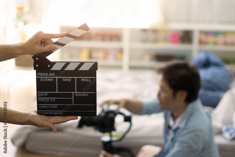 Hand holding clapper board on blurred movie director Hand holding clapper board on blurred movie director