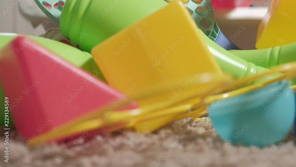 Lovely laughing little kid, preschool blonde, playing with colorful toys in a white box, sitting on the floor in the room Lovely laughing little kid, preschool blonde, playing with colorful toys in a white box, sitting on the floor in the room