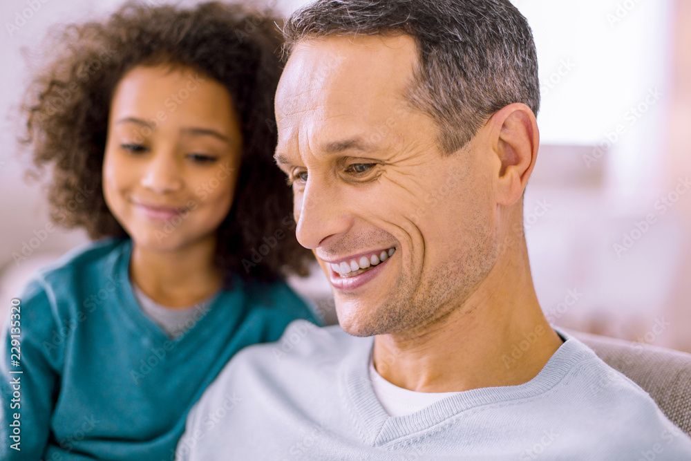 Positive emotions. Pleased young man feeling happiness while being at home with kid Positive emotions. Pleased young man feeling happiness while being at home with kid