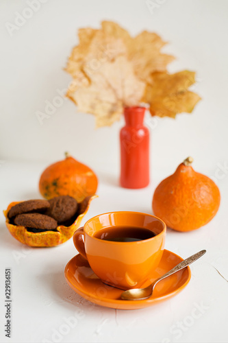 Autumn breakfast.Orange cup of black tea on white photo