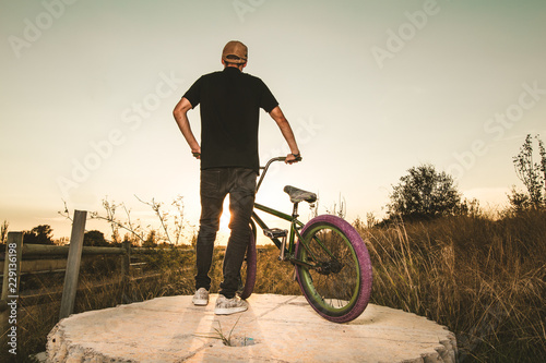 BMX rider at sunset. Guy riding a bmx bike