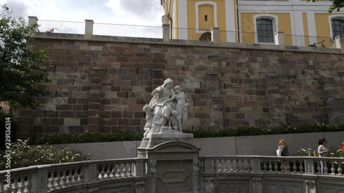 Camera tilts down from the St. Johann Church to the statue 