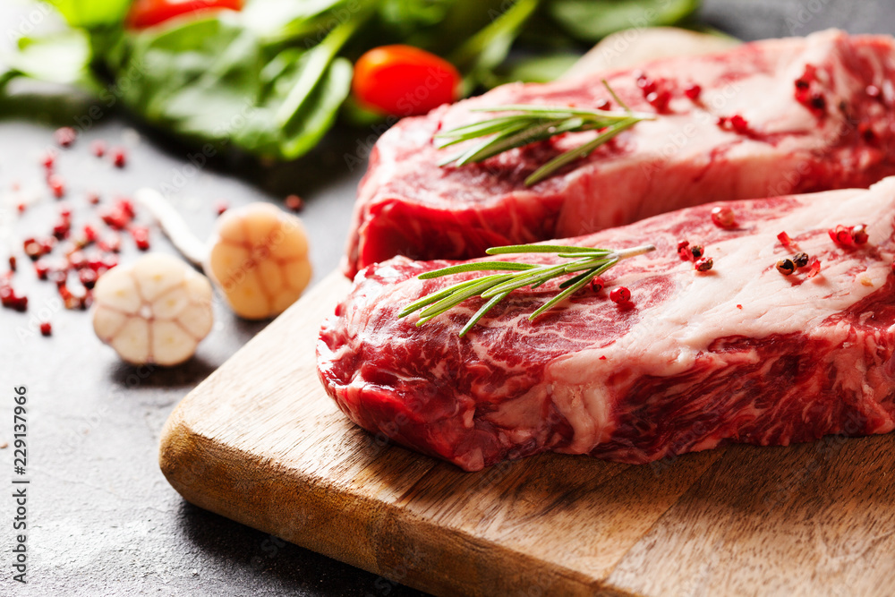 Raw Black Angus Prime meat steaks on wooden board Raw Black Angus Prime meat steaks on wooden board