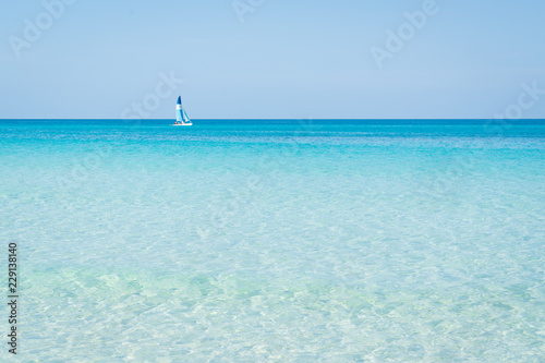 Sailboat sails alone in the Caribbean sea near the coast, wonderful colors turquoise, blue, azure of the sea.sunny day Varadero Cuba.