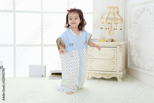the cute little girl was playibg in the room wearing ababy