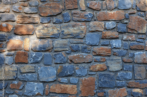Bild auf Leinwand beautiful stone wall of stones of different colors and sizes closeup