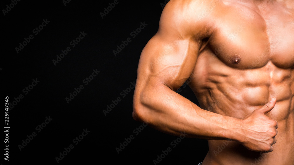 Strong Athletic Man Fitness Model Torso showing six pack abs. isolated on black background. Strong Athletic Man Fitness Model Torso showing six pack abs. isolated on black background.