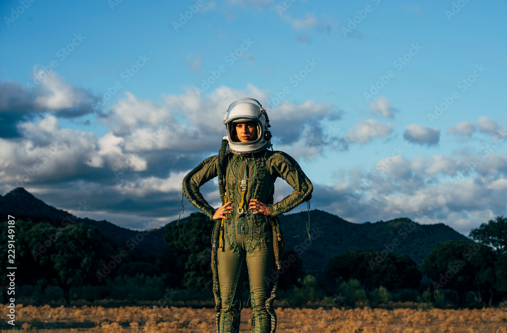 Beautiful woman poses looking at camera dressed as an astronaut. Beautiful woman poses looking at camera dressed as an astronaut.