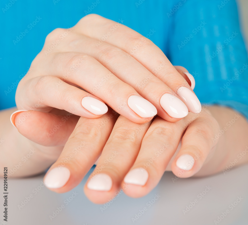 female hand with beige nail design. female hand with beige nail design.