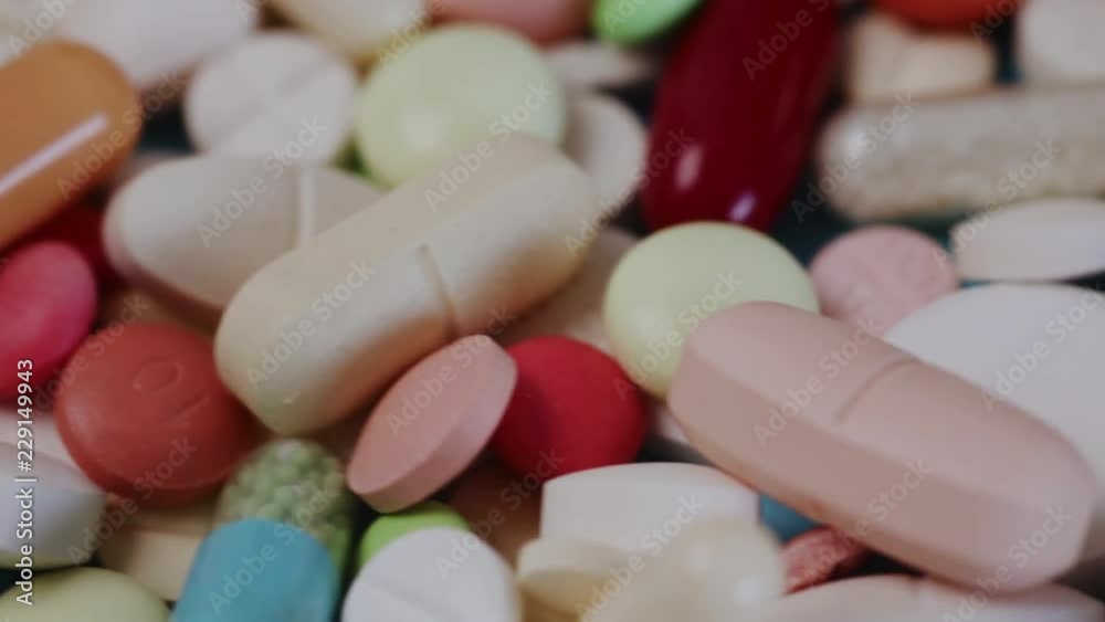 Closeup pan shot of pile of many different pills Closeup pan shot of pile of many different pills