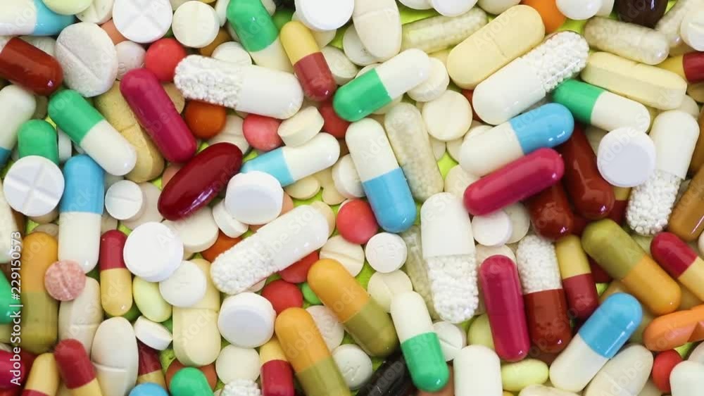 Many colorful medication pills spinning through view Many colorful medication pills spinning through view