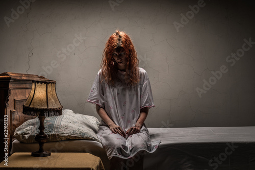 Scary woman possessed by devil in the bed. Exorcism of priest.