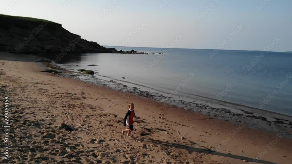 Aerial Slow Motion Of A Cute Little Boy Running Along The Ocean Coast Aerial Slow Motion Of A Cute Little Boy Running Along The Ocean Coast