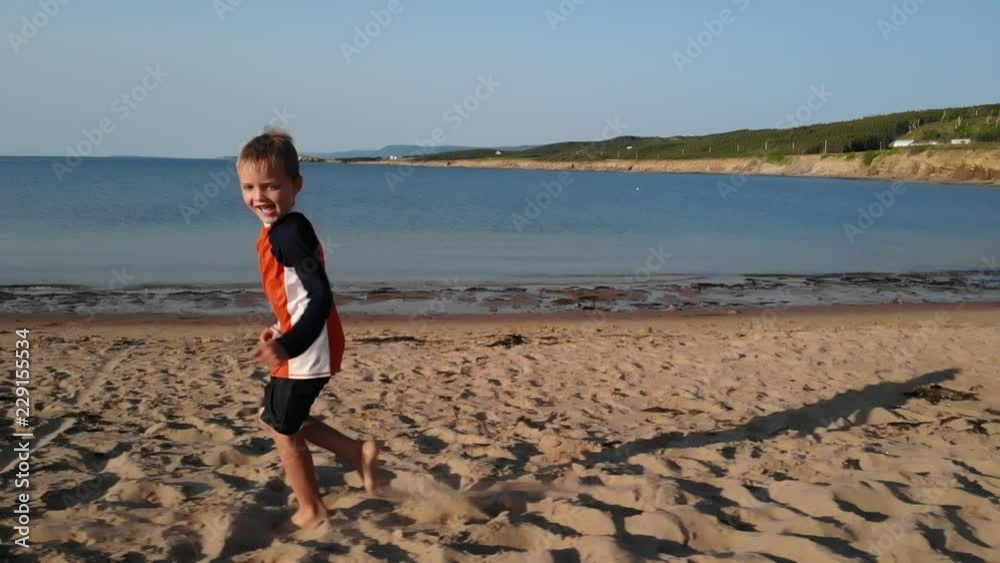 Aerial Slow Motion Of A Little Boy Running Along An Ocean Coast Aerial Slow Motion Of A Little Boy Running Along An Ocean Coast