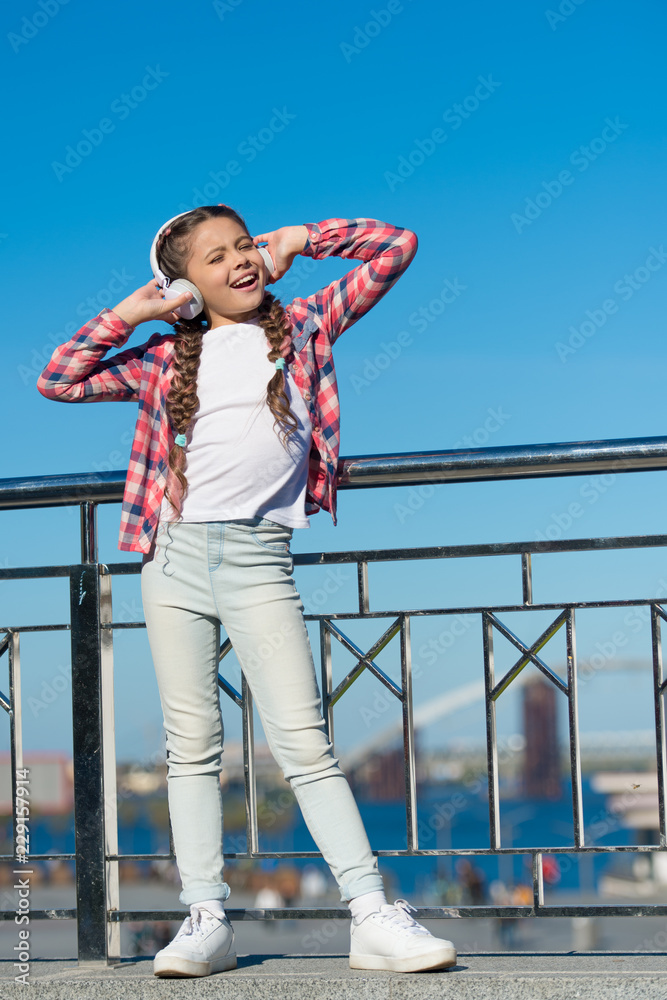 Let the music speak. Small girl listen to music outdoor. Happy small girl. Happy child wear headphones. Small music fan. Just be happy