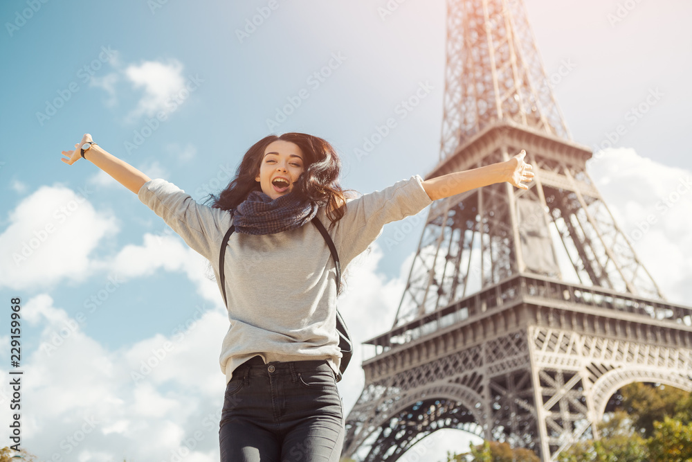 Fototapeta premium Młoda atrakcyjna szczęśliwa kobieta skacze z radości z wieży Eiffla w Paryżu, Francja. Portret podróży turystyczna dziewczyna na urlopowym chodzącym szczęśliwym outdoors. Gorgeous rasy mieszanej azjatyckich kobiet rasy kaukaskiej