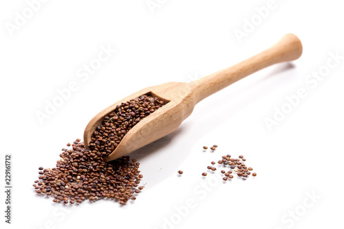 Close-up of pile of red quinoa in a wooden spoon on white background