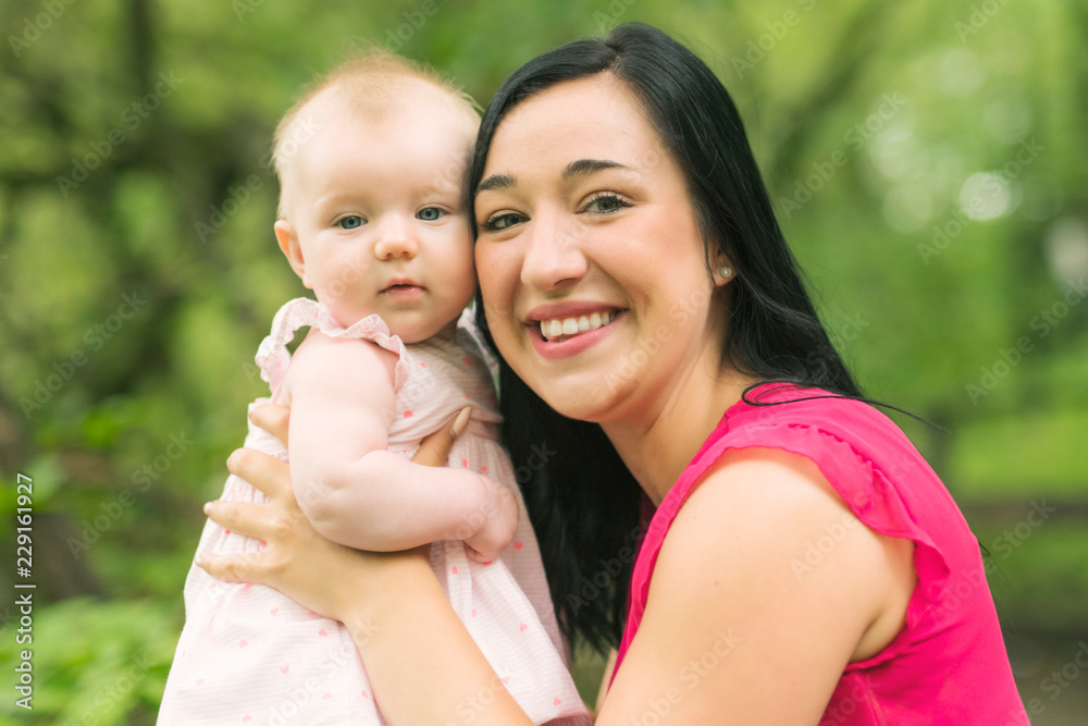 Mother and daughter baby in summer meadow park Mother and daughter baby in summer meadow park