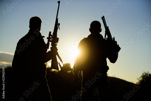 Hunters friends gamekeepers with guns silhouette sky background. Hunters rifles nature environment. Hunter friend enjoy leisure. Hunting with partner provide greater measure safety fun and rewarding