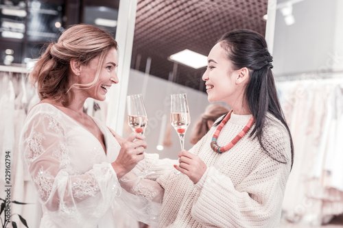 Pleasant communication. Joyful nice women talking about future wedding while drinking champagne © Viacheslav Yakobchuk
