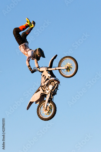 Freestyle motocross rider performs the trick in jump at fmx competitions