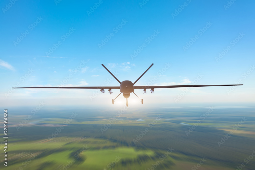 Unmanned military drone patrols the territory, flying over the terrain. The view is straight ahead. - obrazy, fototapety, plakaty 