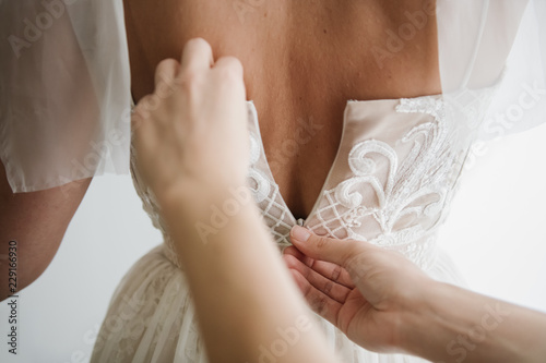Hands helping to bride with dress photo
