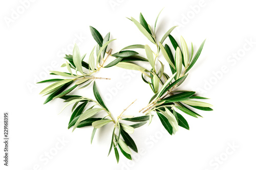 An overhead photo of a wreath made up of olive tree branches, a circular frame with copy space, shot from above on a white background